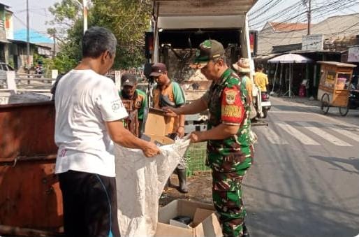 Babinsa Cakung Bersihkan Tumpukan Sampah di Pinggir Jalan