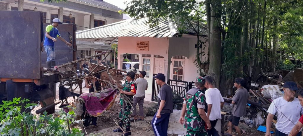 Babinsa Malaka Jaya Bantu Warga Bersihkan Tumpukan Sampah