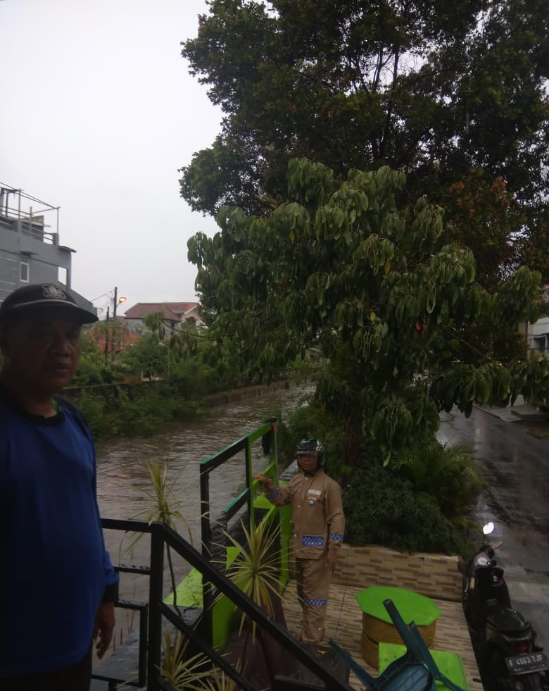 Pastikan Keamanan Warga, Bhabinkamtibmas Polsek Bekasi Barat Pantau Ketinggian Air Kali Cakung