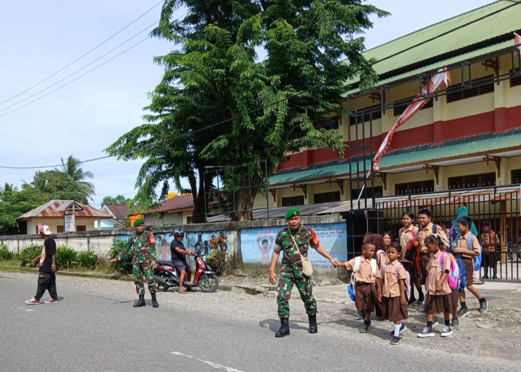 Peduli Keselamatan Anak Sekolah, Secara Rutin Babinsa Koramil Jajaran Kodim 1710/Mimika Bantu Seberangkan Jalan