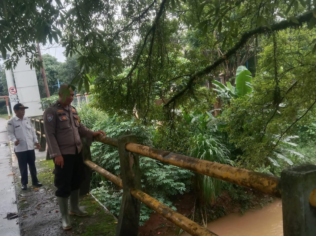 Antisipasi Potensi Genangan, Bhabinkamtibmas Polsek Jatisampurna Pantau Debit Air Kali Cikeas